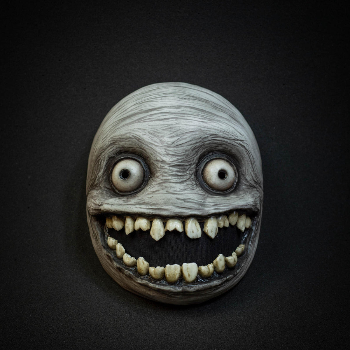 Crazy smile mask with bulging eyes for Halloween or a funny gift